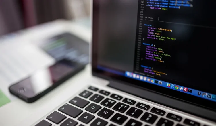 Imagem de um notebook exibindo código de programação, representando estratégias de otimização de sites para o Google em 2026.