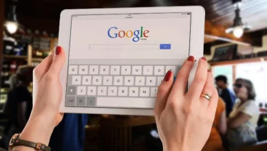 Pessoa usando um tablet para pesquisar no Google, simbolizando estratégias de marketing digital para pequenas empresas competir com grandes marcas no Google