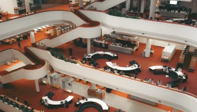 Interior de um museu ou centro cultural com corredores brancos em formato curvo, exposições e visitantes ao redor, em um ambiente amplo e iluminado. Vista geral do espaço, útil para ilustrar Intercâmbio no Canadá: Seu guia completo.